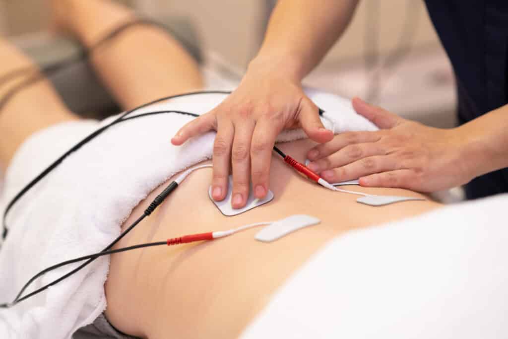 Chiropractic Treatment, Electro stimulation in physical therapy to a young woman